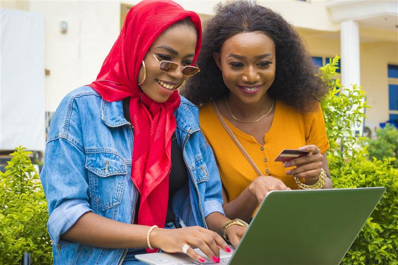 two-pretty-african-ladies-using-their-credit-card-laptop-shop-online