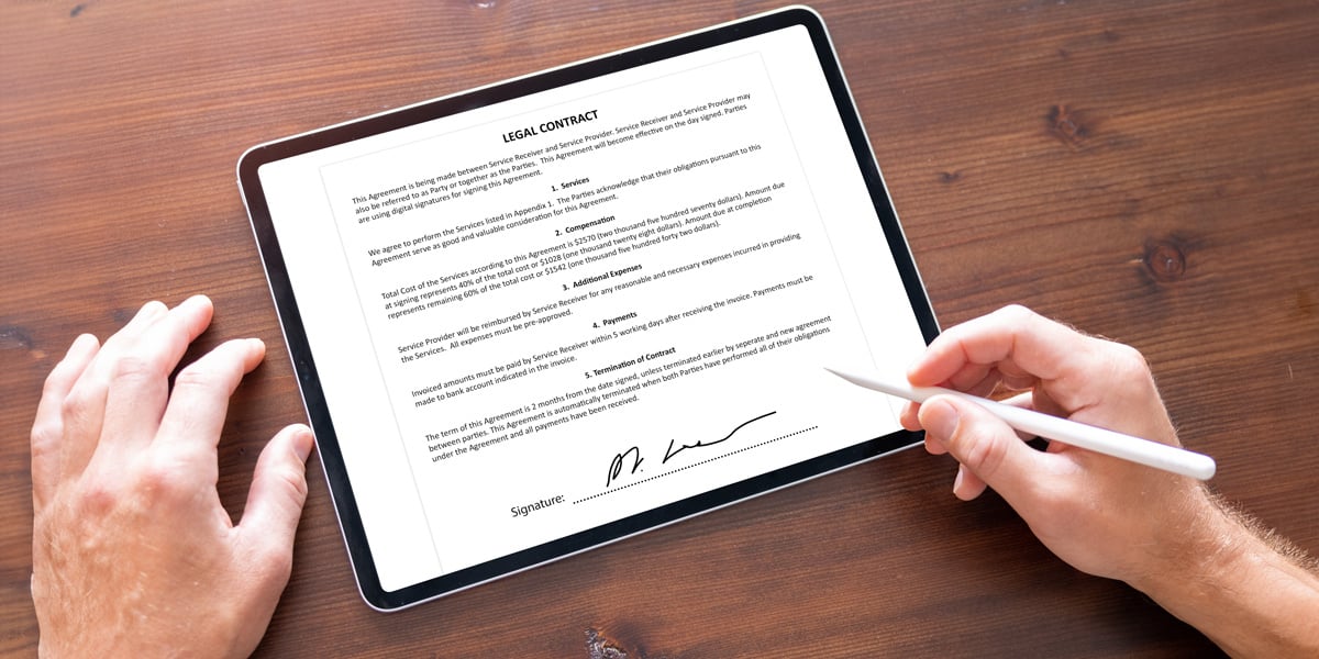 man-signing-document-tablet-computer